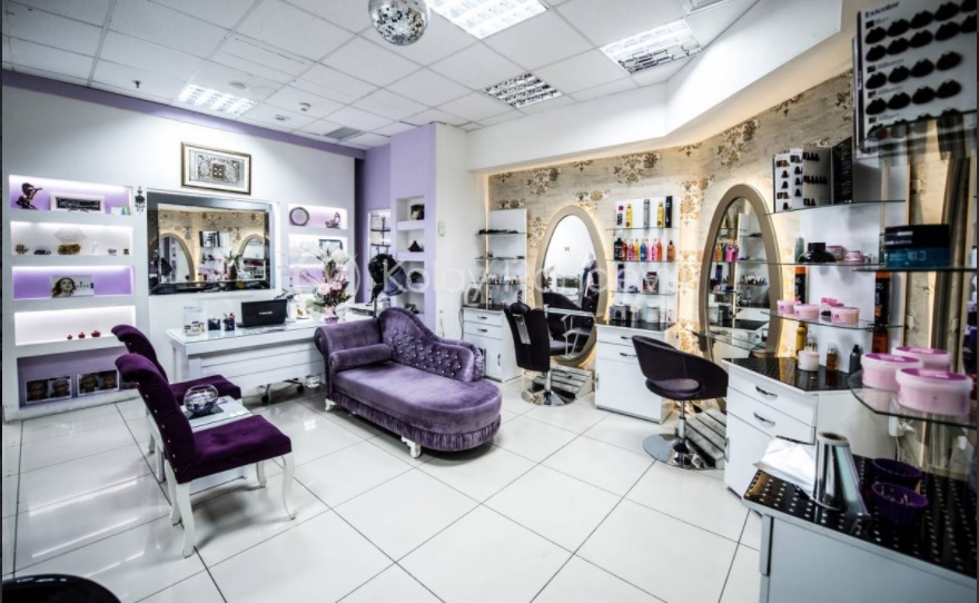 Emel ACAR Güzellik Merkezi salon içi — altın çerçeveli oval aynalar ve lavanta koltuklar
